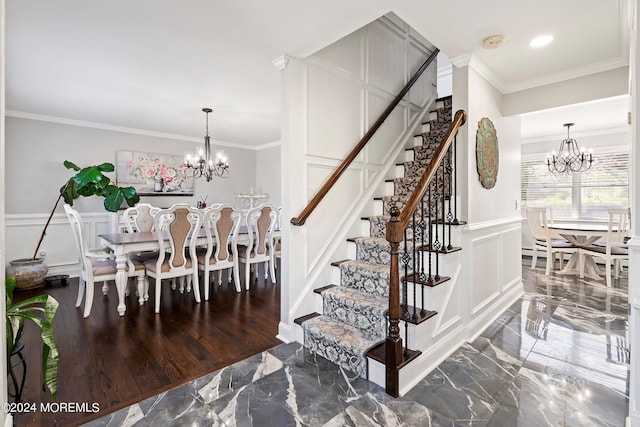 stairs featuring an inviting chandelier and crown molding