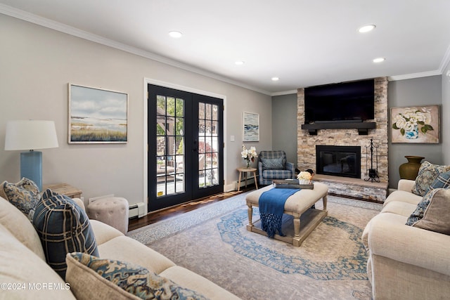 living room with crown molding, baseboard heating, hardwood / wood-style floors, a stone fireplace, and french doors