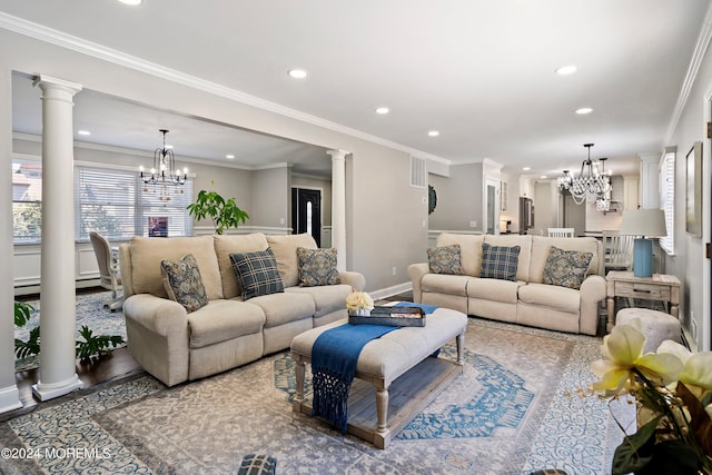 living room with crown molding, decorative columns, and a notable chandelier