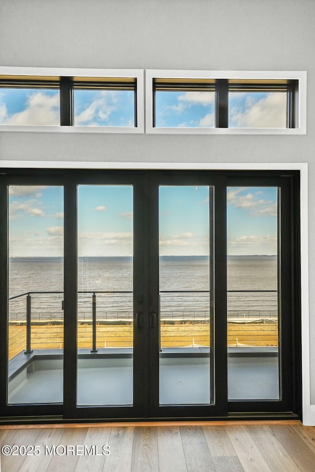 doorway to outside with a water view and hardwood / wood-style floors