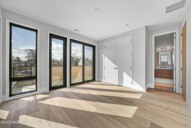 unfurnished room featuring sink and light hardwood / wood-style floors