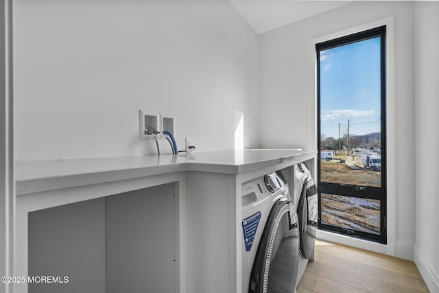 washroom featuring washing machine and clothes dryer and light hardwood / wood-style floors