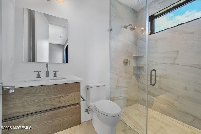 bathroom with vanity, a shower with door, and toilet