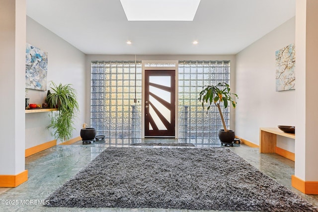 entrance foyer with marble finish floor, a healthy amount of sunlight, and baseboards