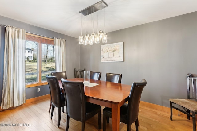 dining space featuring light wood-style flooring and baseboards