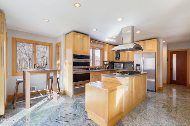 kitchen featuring visible vents, island range hood, appliances with stainless steel finishes, marble finish floor, and a sink