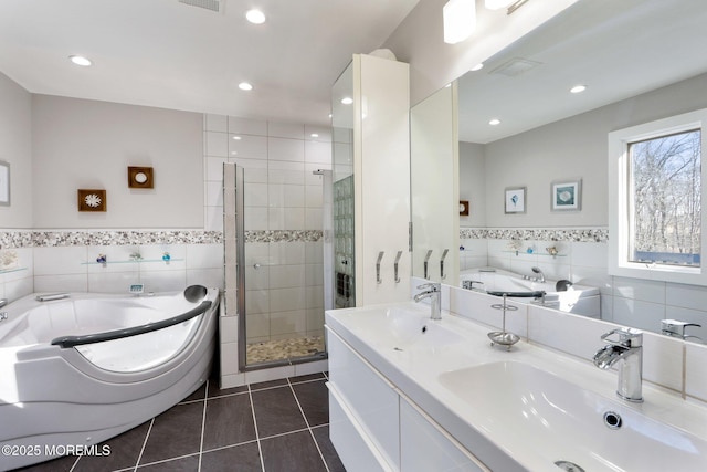 full bath with a shower stall, a sink, tile walls, and tile patterned floors