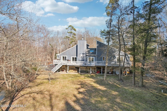 back of property with a chimney, stairway, a deck, and a lawn