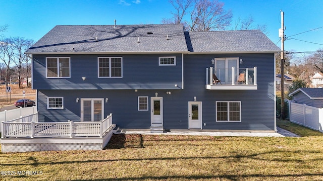 back of property with a lawn and a balcony