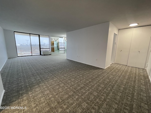 unfurnished living room featuring baseboards, floor to ceiling windows, and carpet flooring