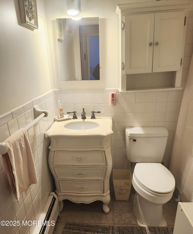 bathroom featuring tile walls, vanity, toilet, and baseboard heating