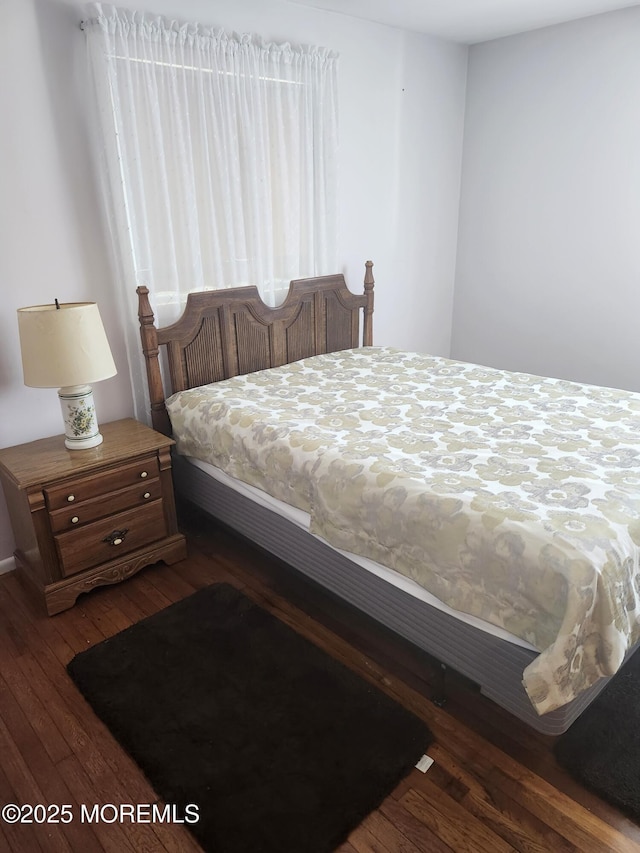 bedroom with dark hardwood / wood-style flooring