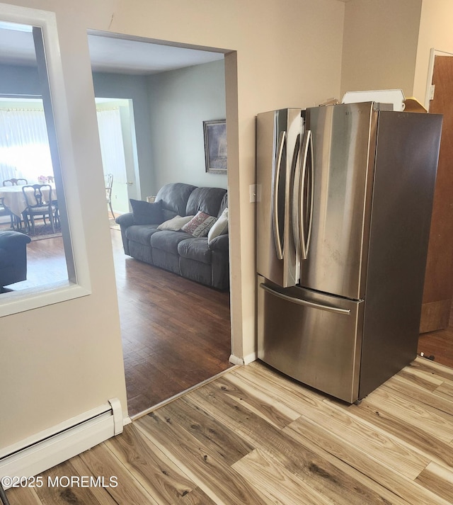 kitchen featuring hardwood / wood-style flooring, stainless steel fridge, and a baseboard radiator