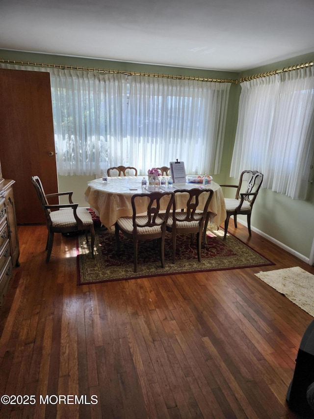 dining area with baseboards and dark wood-type flooring