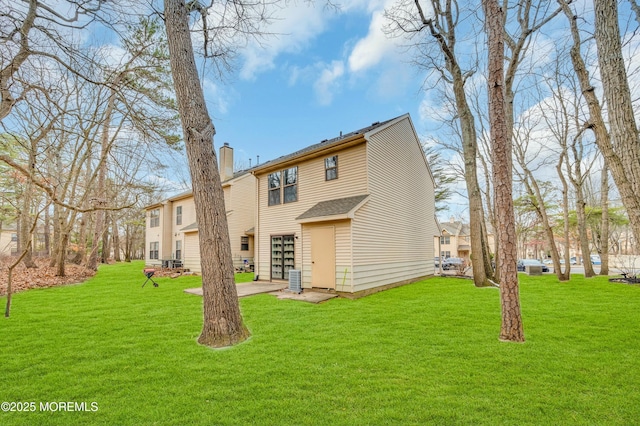 rear view of property with central AC and a lawn