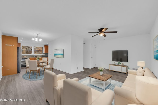 living room featuring hardwood / wood-style flooring and ceiling fan with notable chandelier