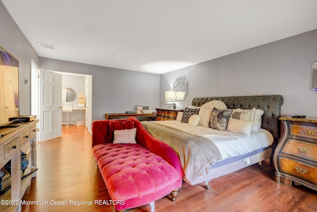 bedroom with visible vents and wood finished floors