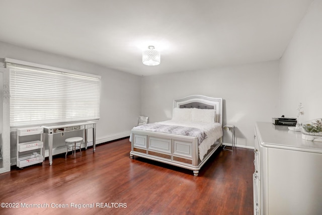 bedroom with dark wood finished floors and baseboards