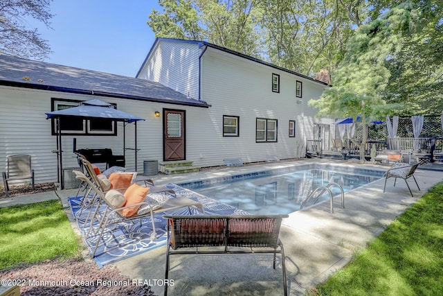 rear view of house with a patio, fence, an outdoor pool, and an outdoor living space