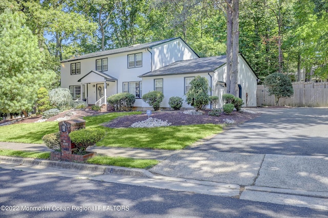 view of front of home featuring aphalt driveway, fence, a garage, and a front yard