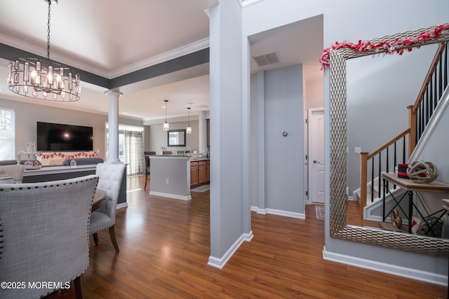 interior space featuring ornate columns, crown molding, and dark wood-type flooring