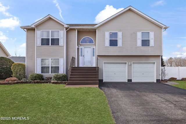 raised ranch featuring a garage and a front lawn