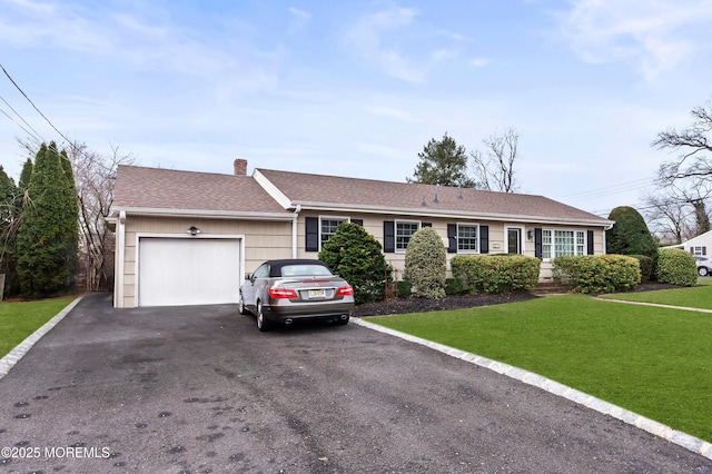 single story home featuring a chimney, a shingled roof, an attached garage, driveway, and a front lawn