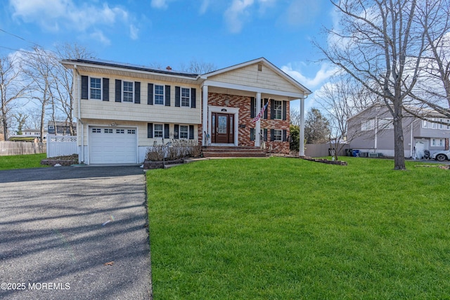 bi-level home featuring a garage and a front yard