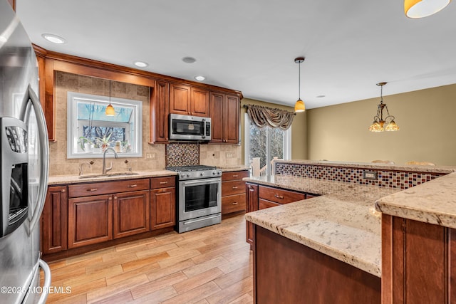 kitchen featuring pendant lighting, sink, appliances with stainless steel finishes, plenty of natural light, and decorative backsplash