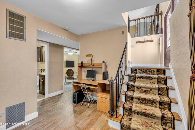 home office with ceiling fan and light hardwood / wood-style flooring