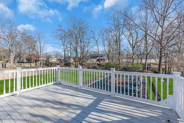 deck featuring a swimming pool and a yard