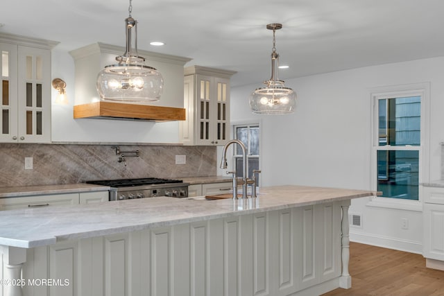 kitchen with light stone countertops, white cabinets, and decorative light fixtures