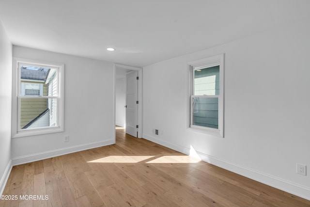 spare room featuring a wealth of natural light and light wood-type flooring