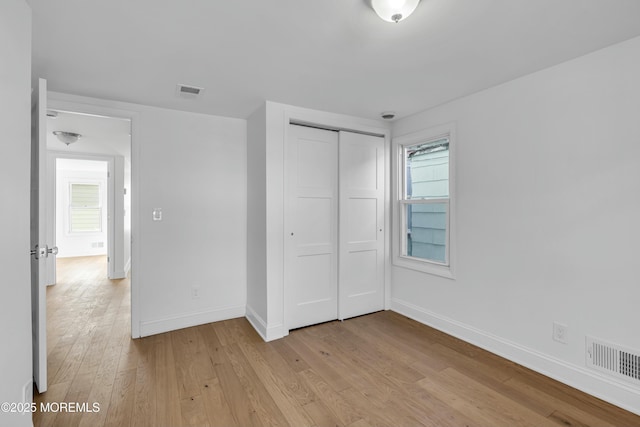 unfurnished bedroom featuring a closet and light wood-type flooring