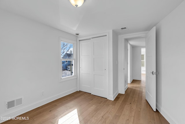 unfurnished bedroom with light hardwood / wood-style flooring and a closet