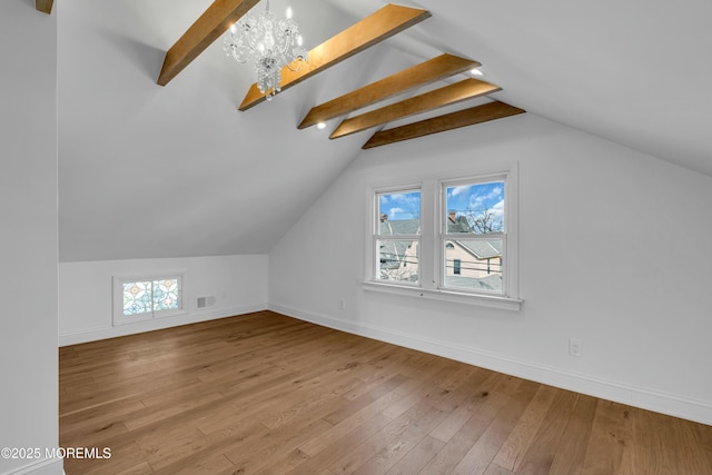 bonus room featuring lofted ceiling with beams, hardwood / wood-style floors, and a notable chandelier