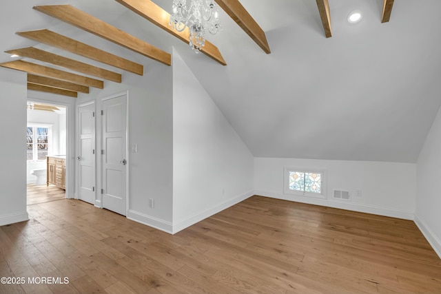 additional living space featuring vaulted ceiling with beams, an inviting chandelier, and light hardwood / wood-style floors