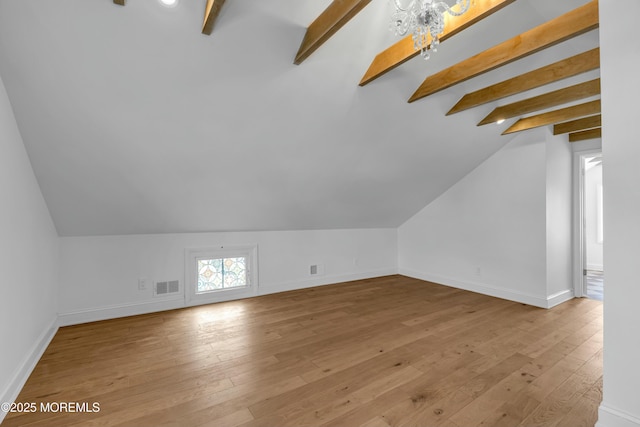 bonus room featuring an inviting chandelier, lofted ceiling with beams, and light hardwood / wood-style flooring