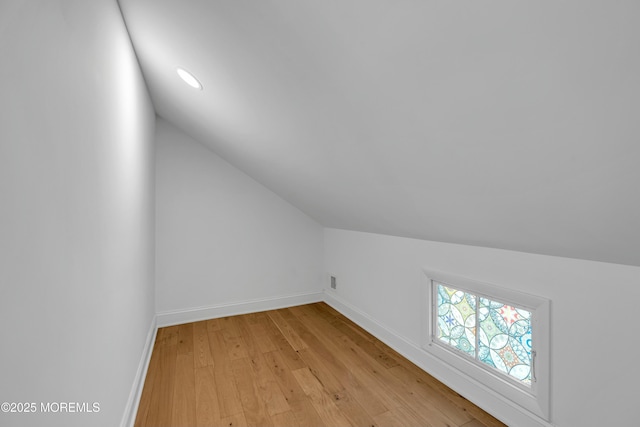 bonus room featuring lofted ceiling and light wood-type flooring