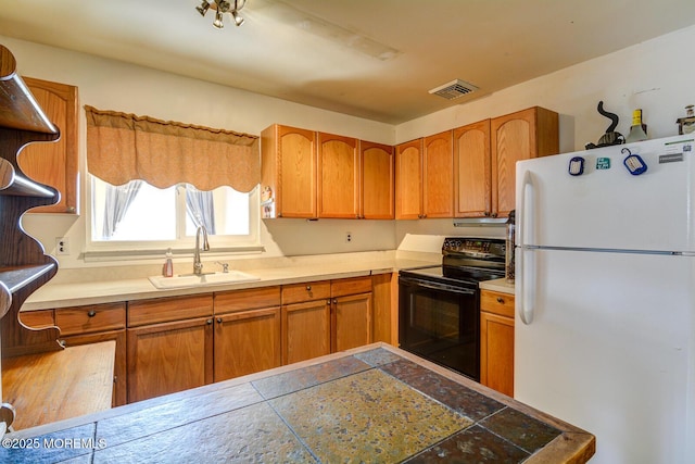 kitchen with white refrigerator, sink, and black range with electric cooktop