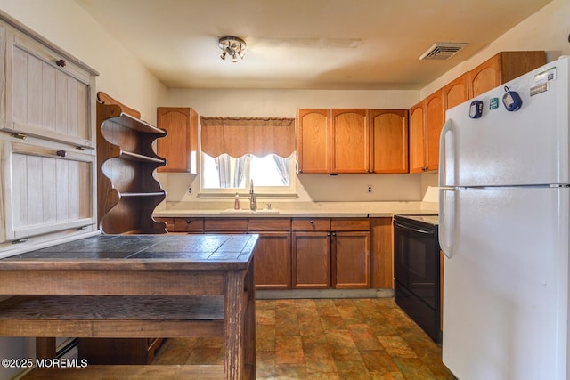 kitchen with white refrigerator, sink, tile counters, and black / electric stove