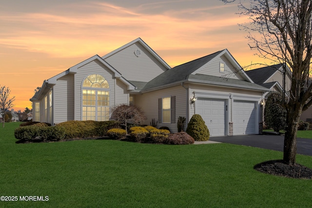 view of front of property featuring a garage and a lawn