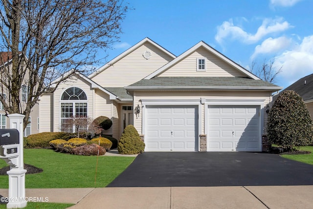 view of front of house featuring a garage and a front lawn