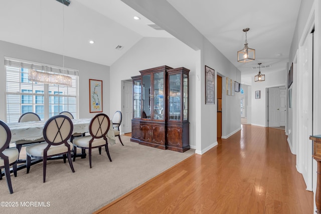 dining room featuring vaulted ceiling and wood-type flooring