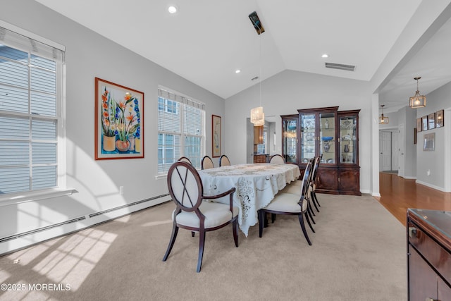 dining area with light carpet, vaulted ceiling, and a baseboard heating unit