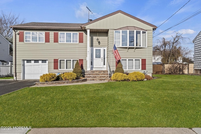 split foyer home with a garage and a front lawn