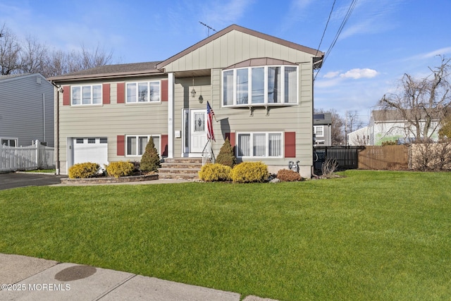 bi-level home featuring a garage and a front yard