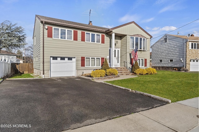 bi-level home featuring a garage and a front yard