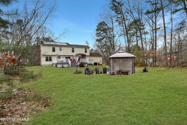 657 Toms River Rd, Jackson, NJ 08527 - back of property featuring solar panels, a chimney, a lawn, and a deck