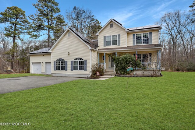 657 Toms River Rd, Jackson, NJ 08527 - traditional-style house featuring an attached garage, driveway, a front yard, covered porch, and solar panels